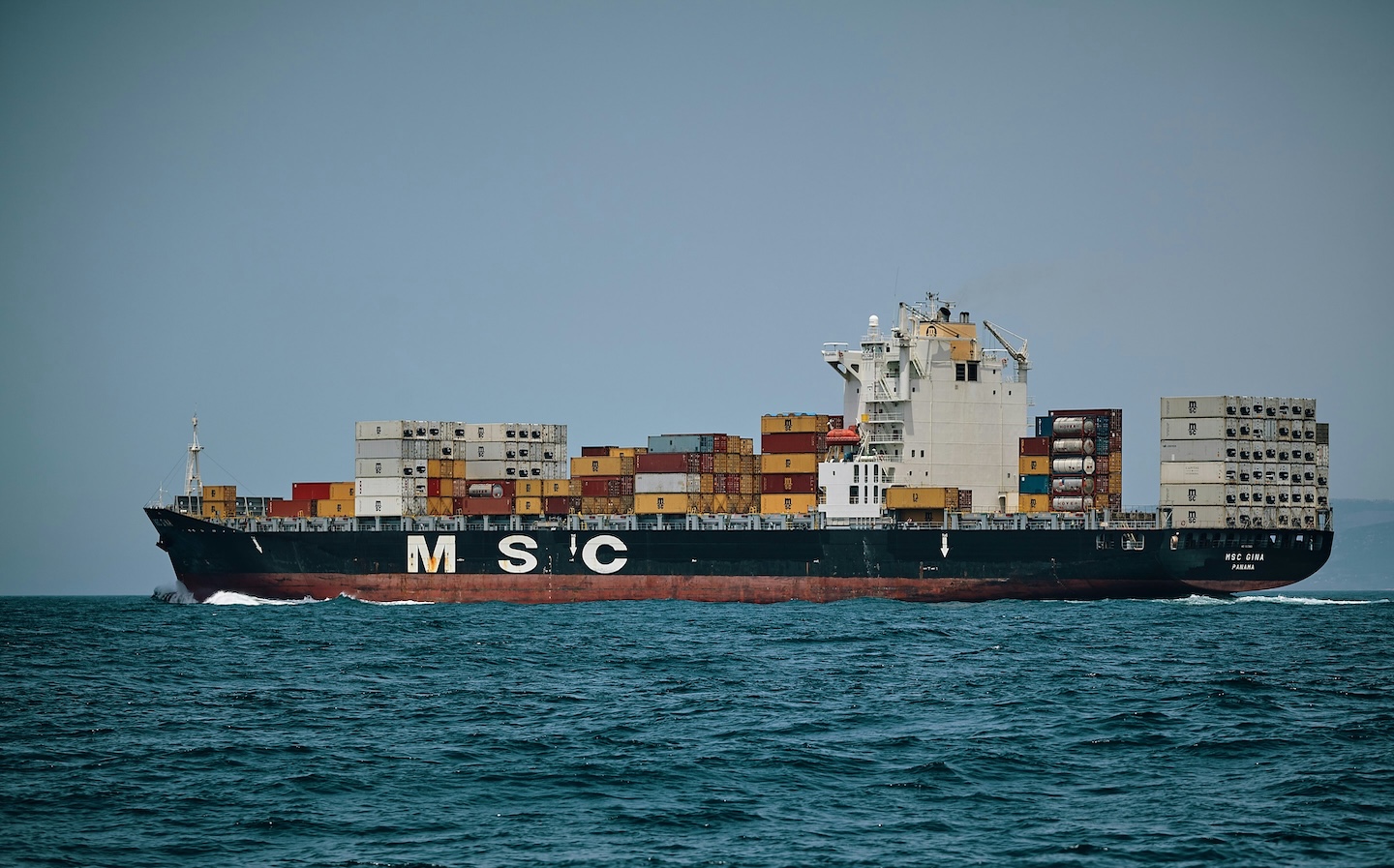 Container ship at sea shown after its tiled watermark was removed by AI