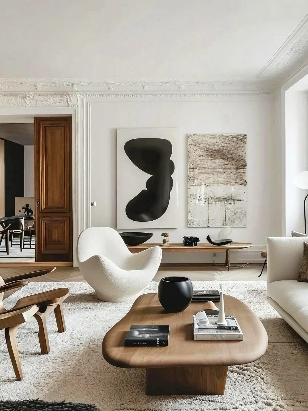 Minimalist living room with a wooden coffee table, white armchair and abstract wall art, shown as an example Home & Living note